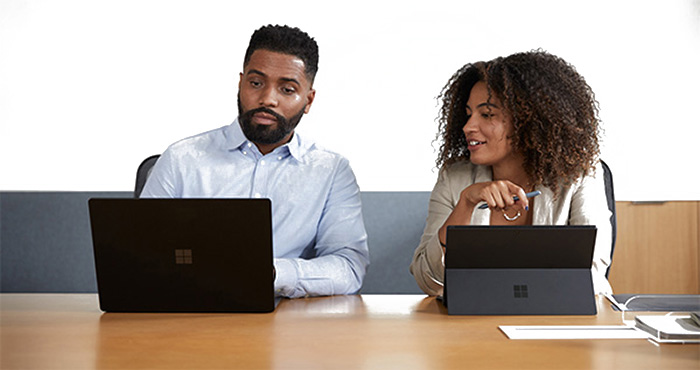 2 professionals training on Microsoft Surface laptops